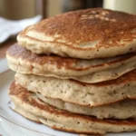 Stack of golden-brown buckwheat pancakes on a white plate