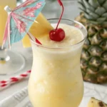 Coco Lopez piña colada recipe with coconut cream in a chilled glass with cherry and pineapple