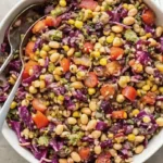 Dense bean salad with beans, corn, cabbage, and tomatoes.