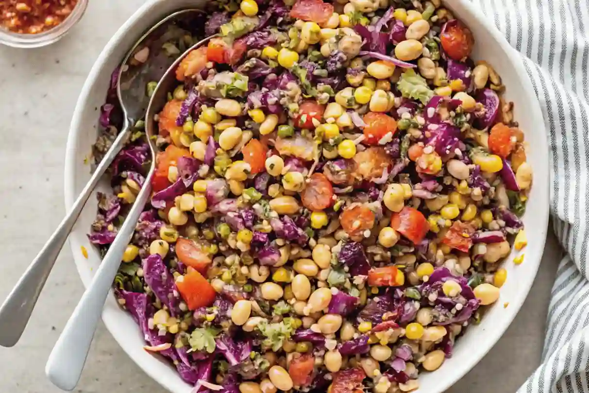 Dense bean salad with beans, corn, cabbage, and tomatoes.
