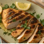 Mediterranean chicken marinade recipe served with fresh herbs, lemon, and hummus.