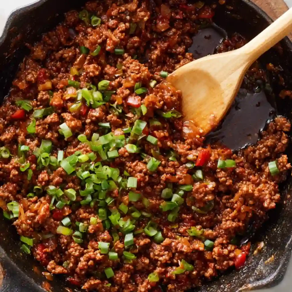 Ground beef browning in a skillet with garlic for the casserole filling.
